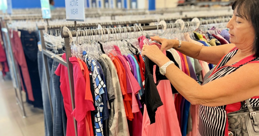 woman looking at thrift store clothing