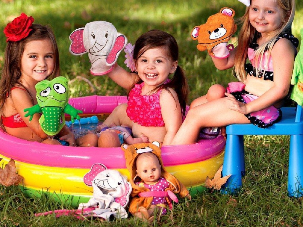 girls in pool in grass with baby dolls