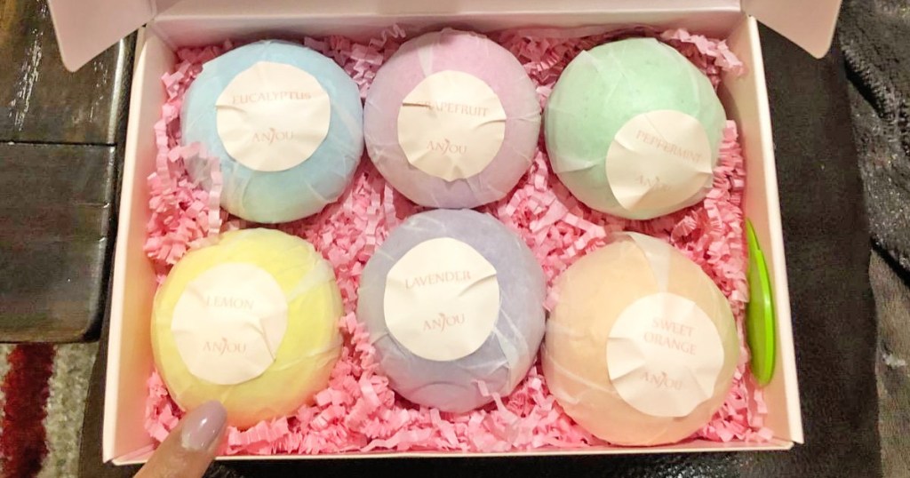 gift box with six bath bombs in various colors with pink tissue shreds under them