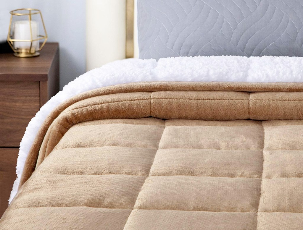 tan colored sherpa fleece blanket on a bed