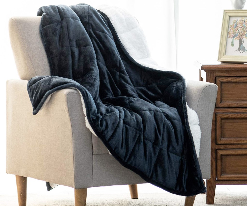 blue sherpa fleece blanket on a cream colored accent chair