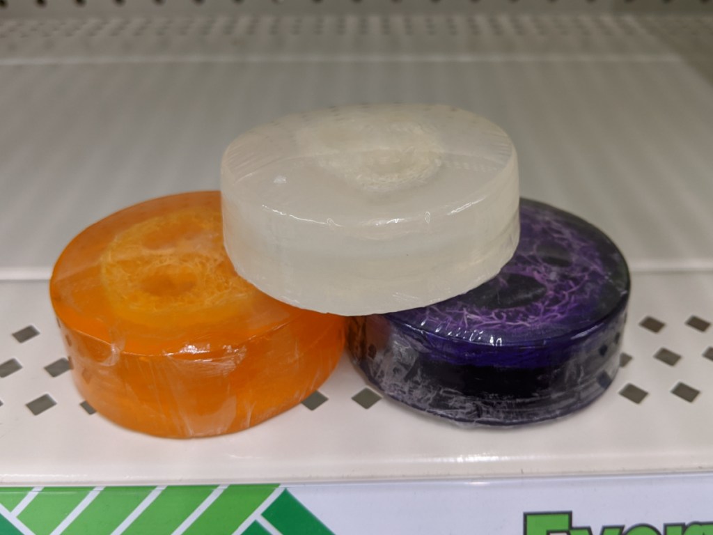 3 colorful round bars of soap sitting on store shelf at dollar tree