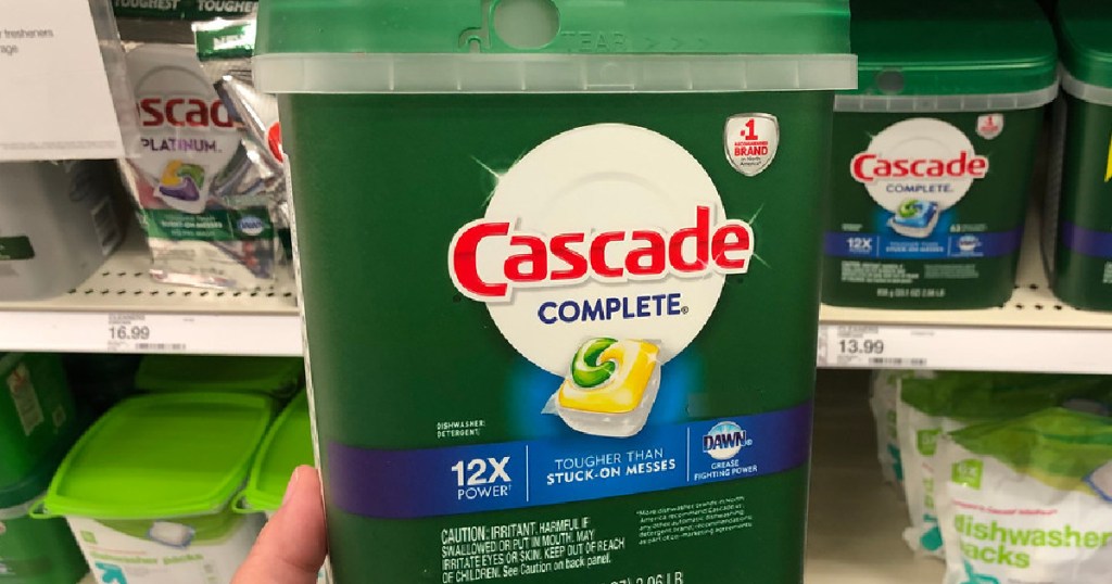 hand holding large tub of dish detergent pacs in store aisle