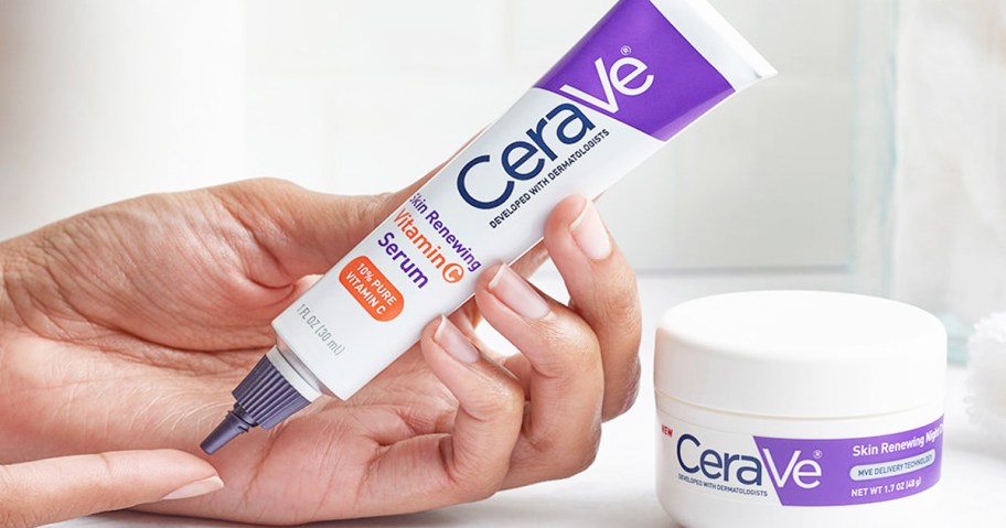 person holding a white and purple tube of CeraVe vitamin c facial serum