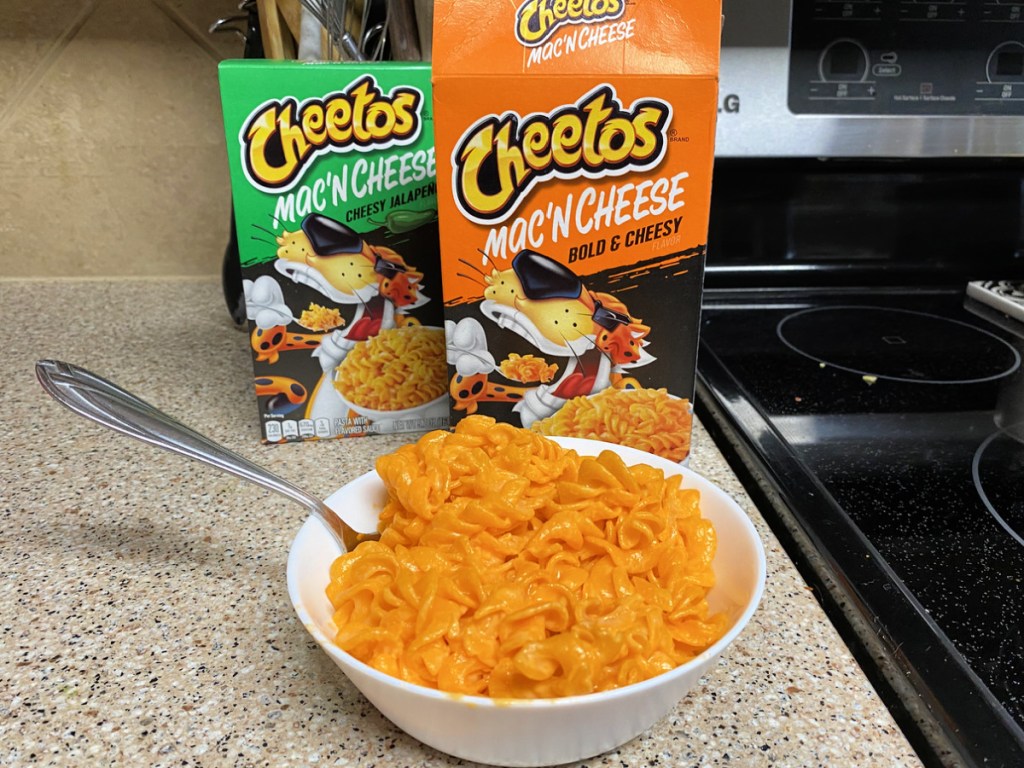 Cheetos Mac 'N Cheese boxes with bowl of mac on countertop