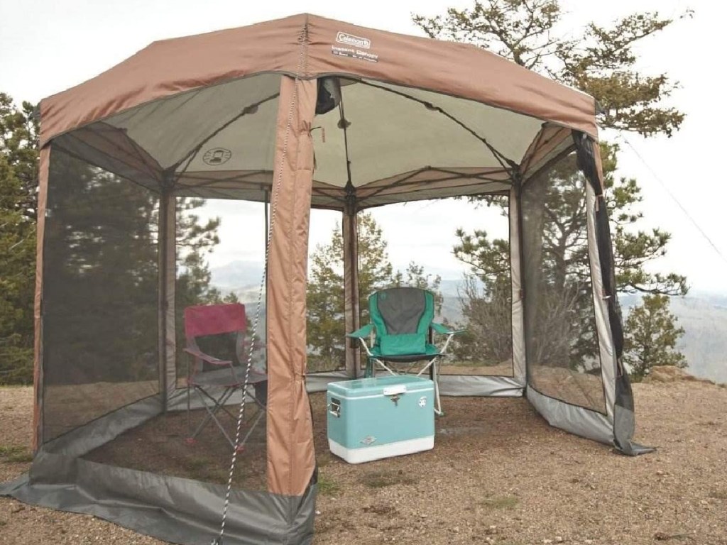 Coleman large enclosed canopy with folding chairs and a cooler inside