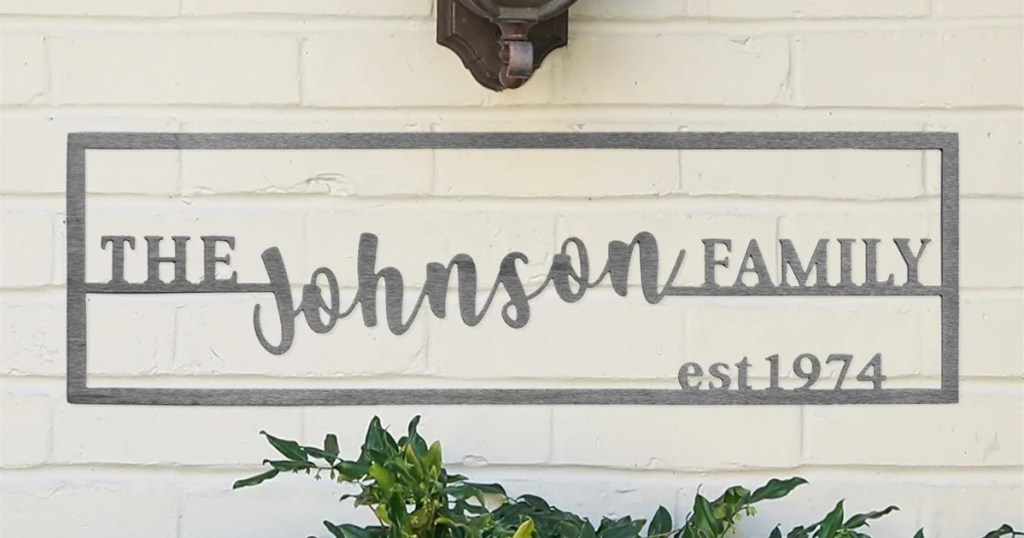 family name plaque on outdoor wall with foliage