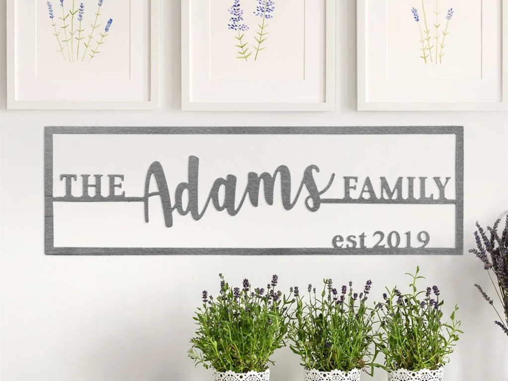 family name plaque on white wall, plants, and floral paintings