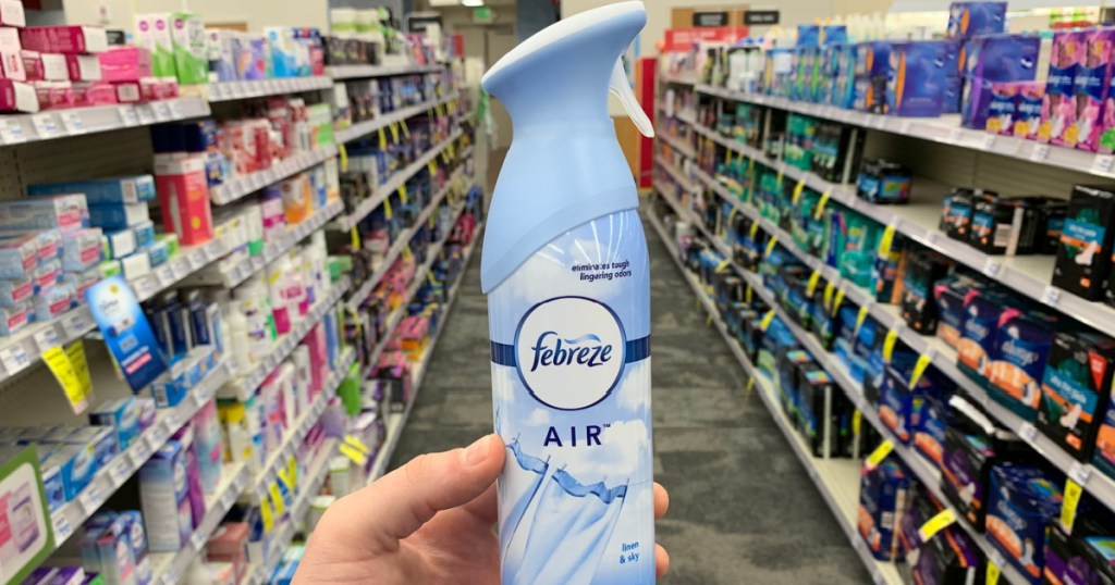 hand holding air freshener spray bottle in store aisle
