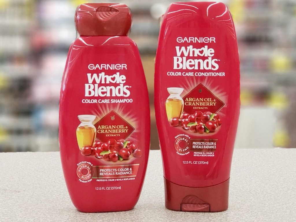 two red bottles of Garnier Whole Blends shampoo and conditioner on checkout counter at Walgreens