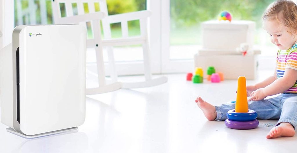 air purifier on floor near child playing with toys