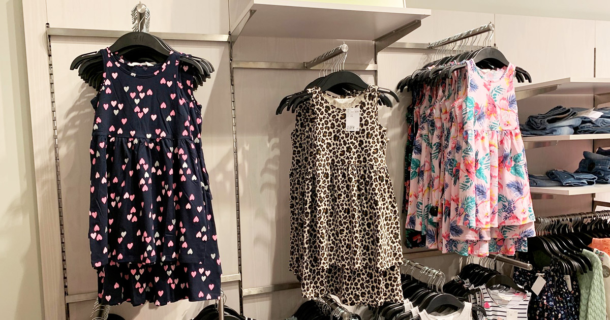 patterned girls dresses pn hangers hanging on store display wall at H&M
