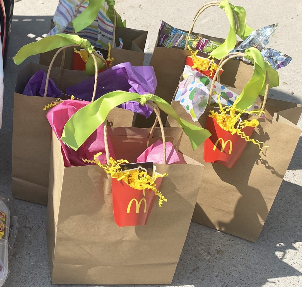 brown paper gift bags with tissue paper and McDonald's fry cups attached to the outside with gift cards inside