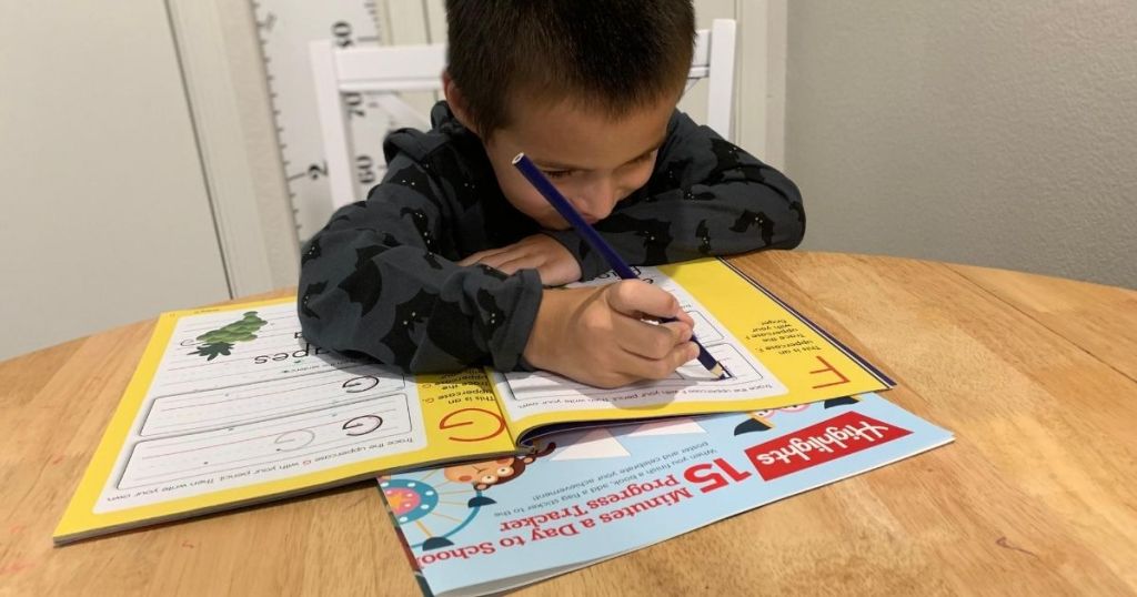 boy writing in a Highlights workbook