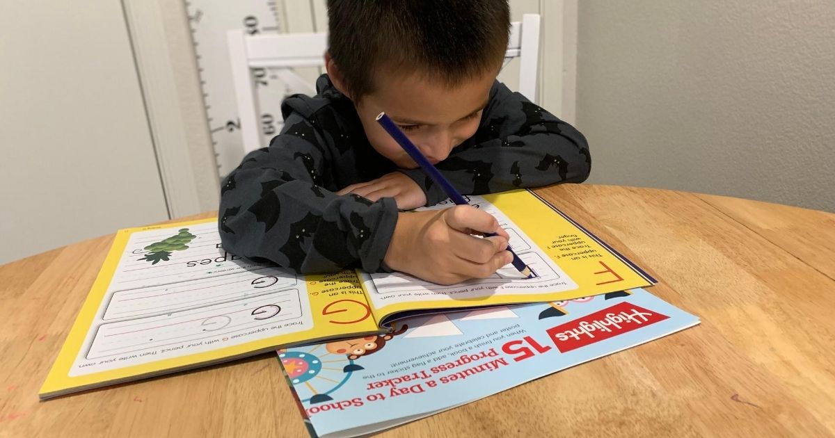 boy writing in a Highlights workbook