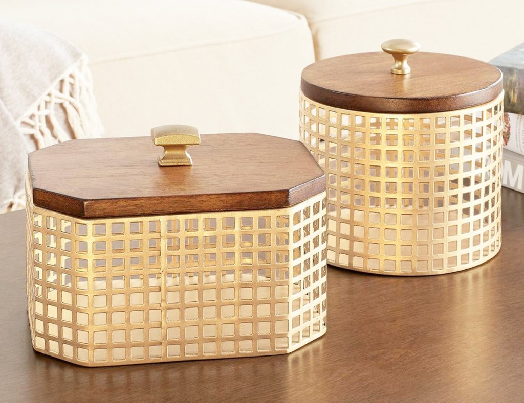 gold metal rectangular and round baskets with wooden lids on wood table