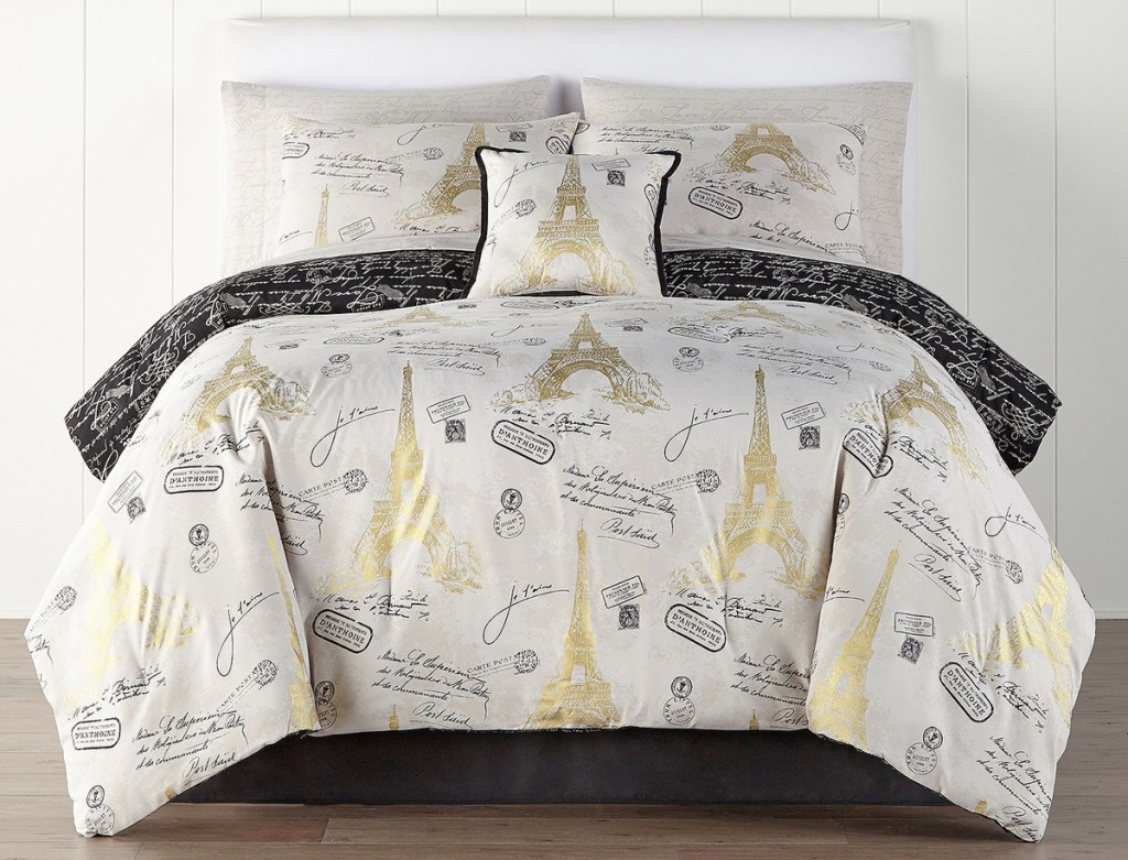 white comforter with black and gold paris and eiffel tower prints on a bed with matching pillow cases and shams