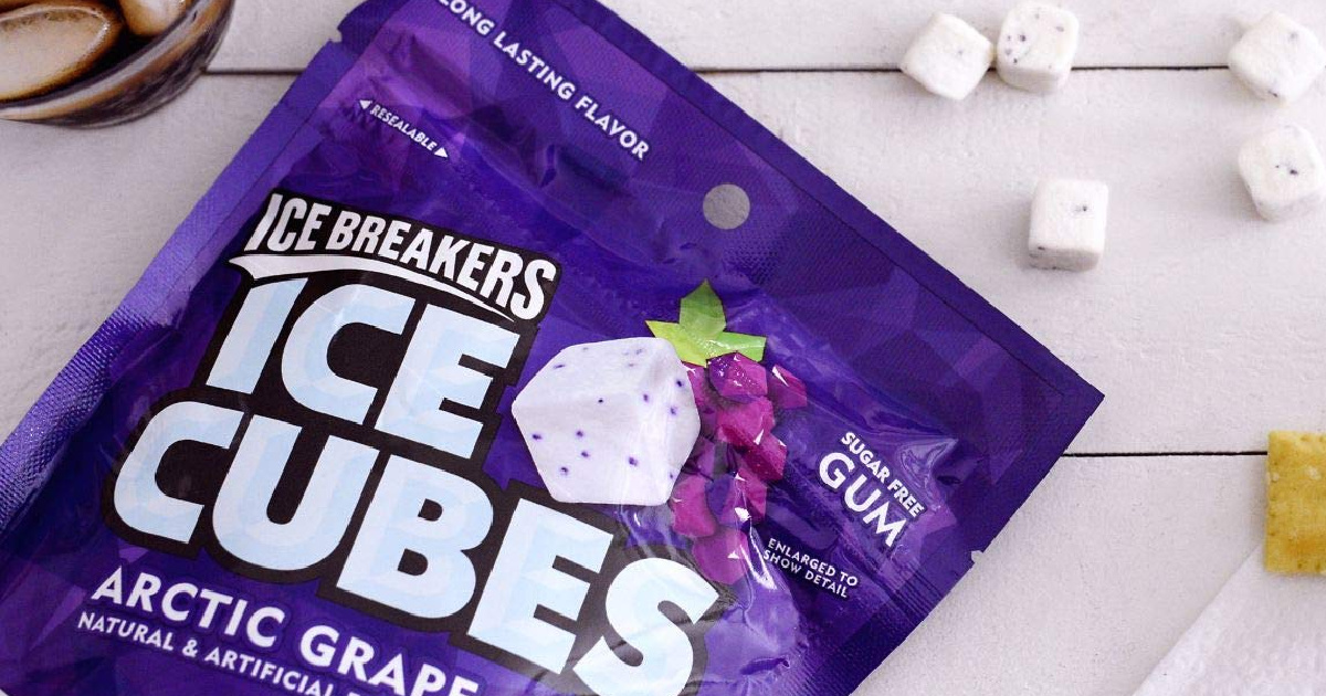 bag of grape gum cubes on table with glass of soda