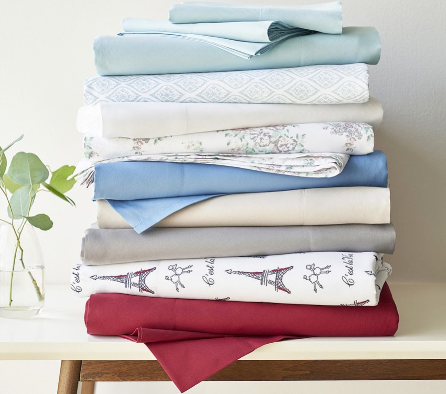 pile of folded sheets on a table in various colors and prints