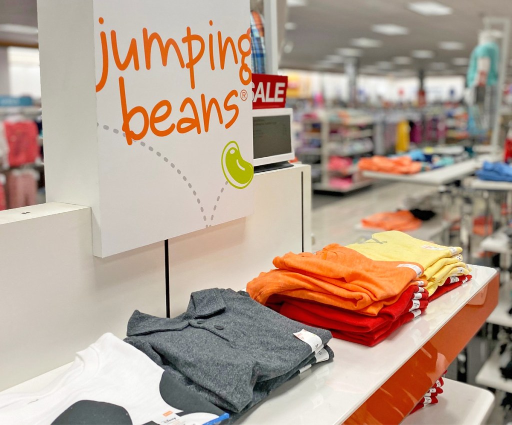 jumping beans sign on a store display of folded boys shirts