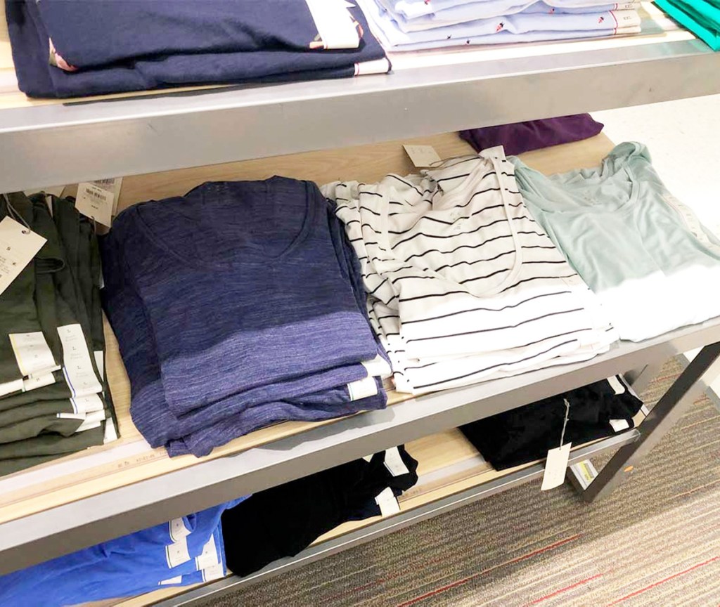 folded women's tees in various colors and prints on a Kohl's store display shelf