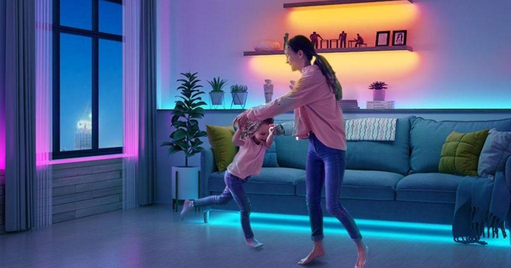woman and child dancing in living room with colorful lights