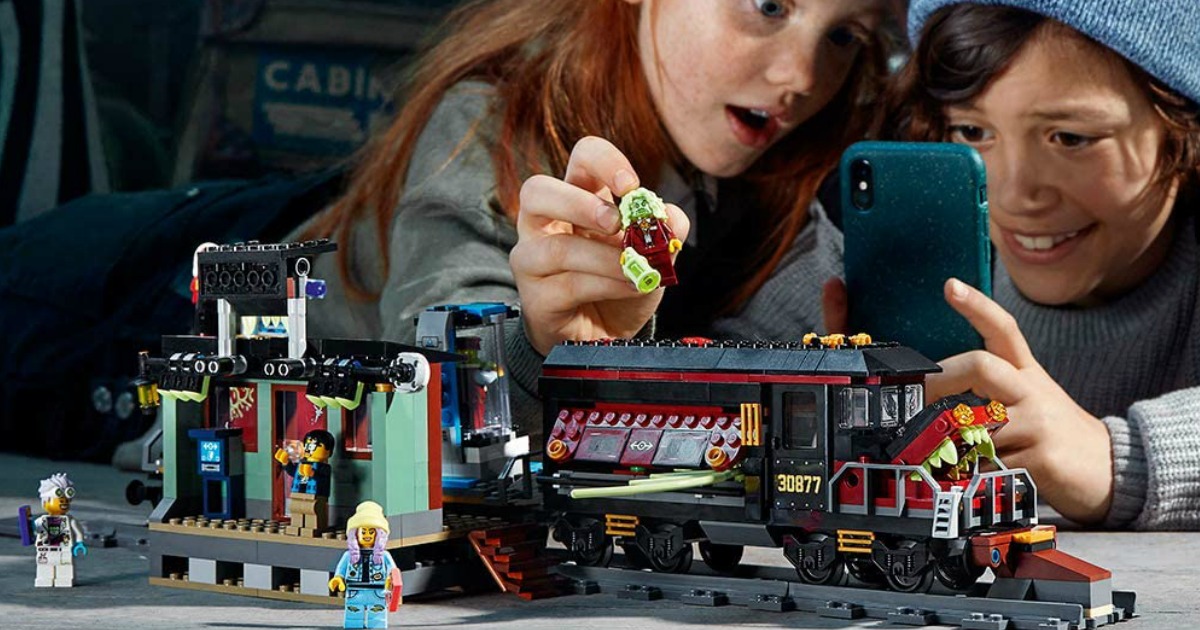 kids playing with a lego set and their phone