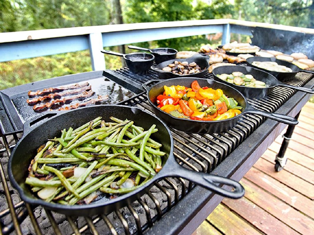 cast iron grill pans filled with food on outdoor grill