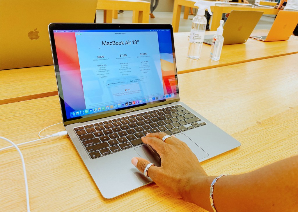 hand on keyboard of macbook air in apple store