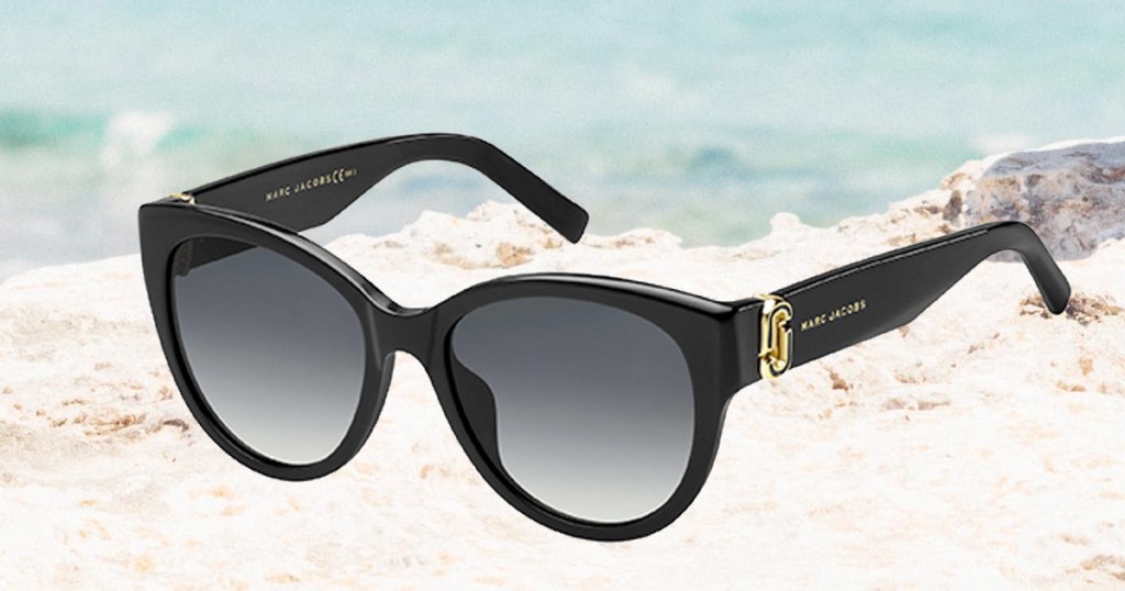 pair of black Marc Jacobs round cat eye sunglasses on beach