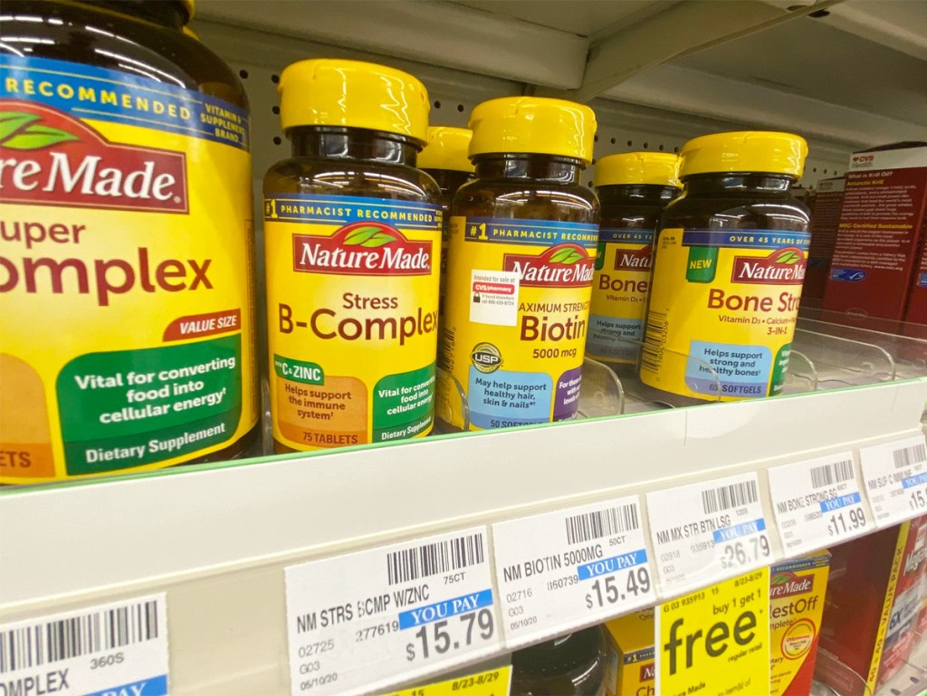 yellow and brown bottles of Nature Made vitamins on CVS store shelf with yellow sale tags