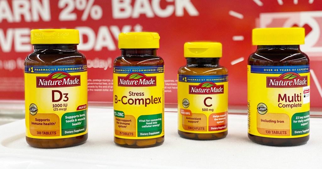 four brown and yellow bottles of Nature Made vitamins on CVS store shelf