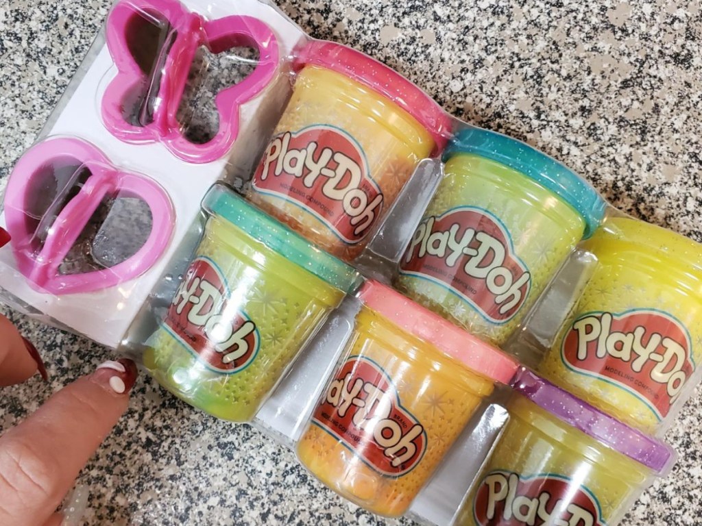 6 tubs of glitter play-doh and two pink cutters