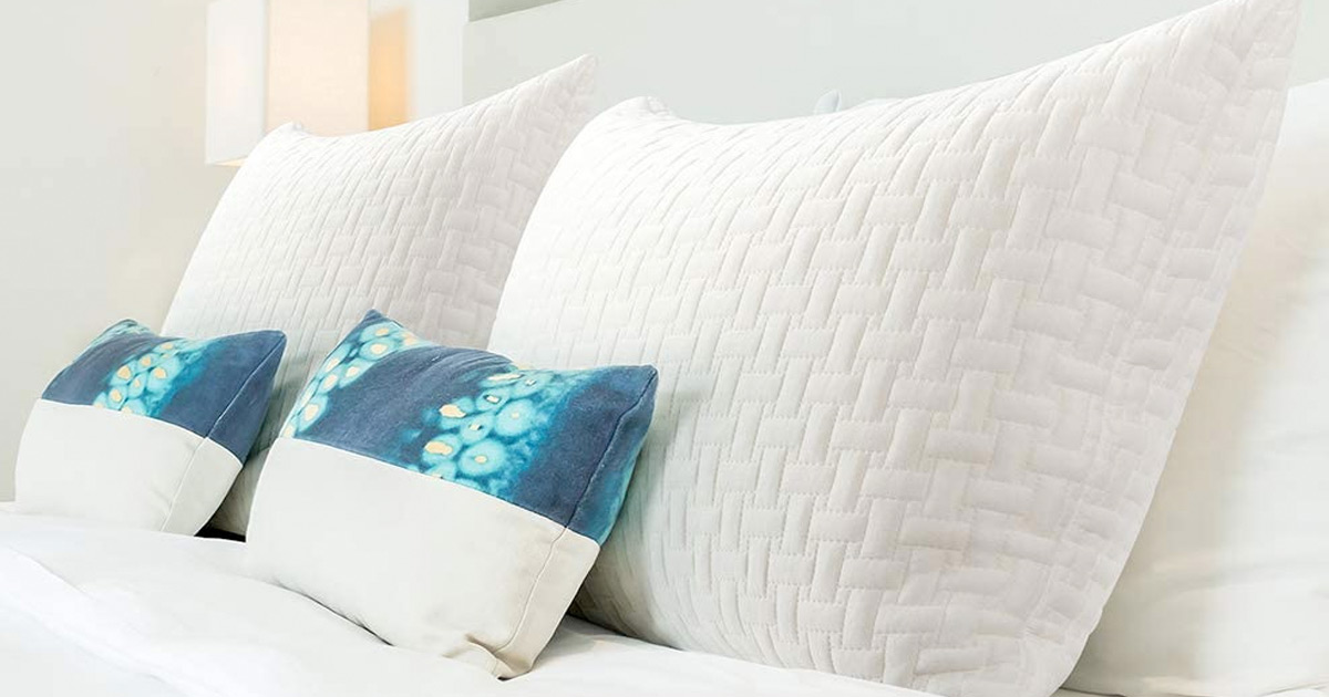 two white memory foam pillows and two blue throw pillows on a bed
