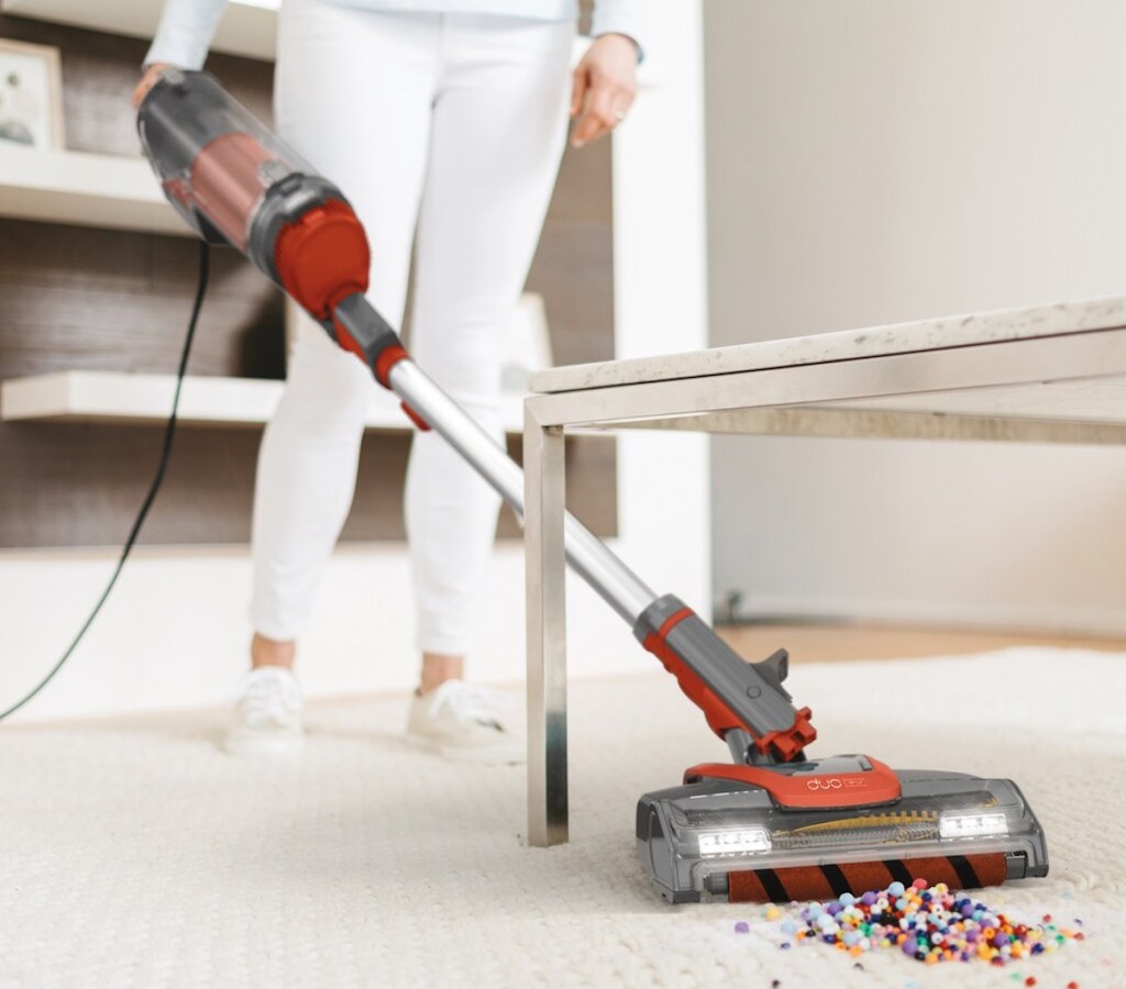 woman vacuuming up beads