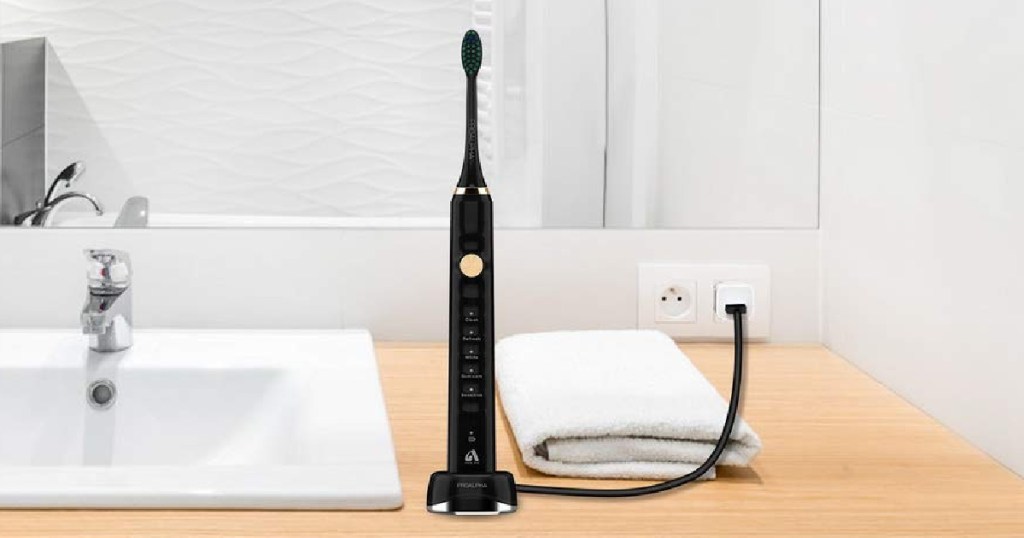 black electric toothbrush plugged in and sitting on a bathroom counter