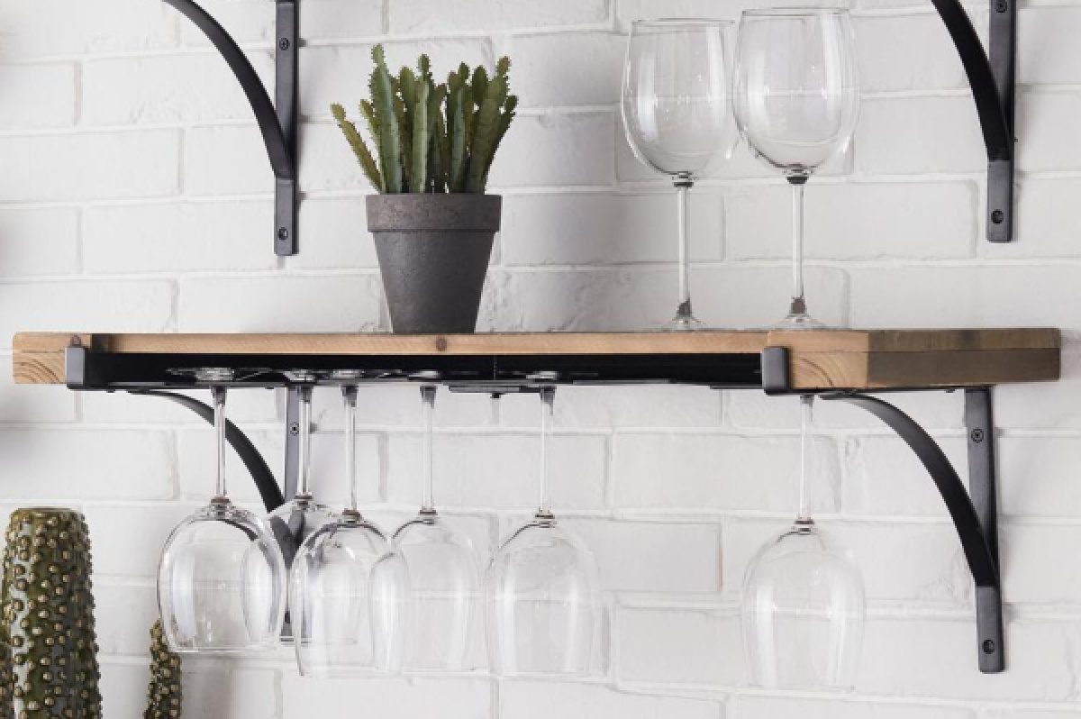 wine glasses handing on wine glass organizer shelf, glasses on top shelf, and plant