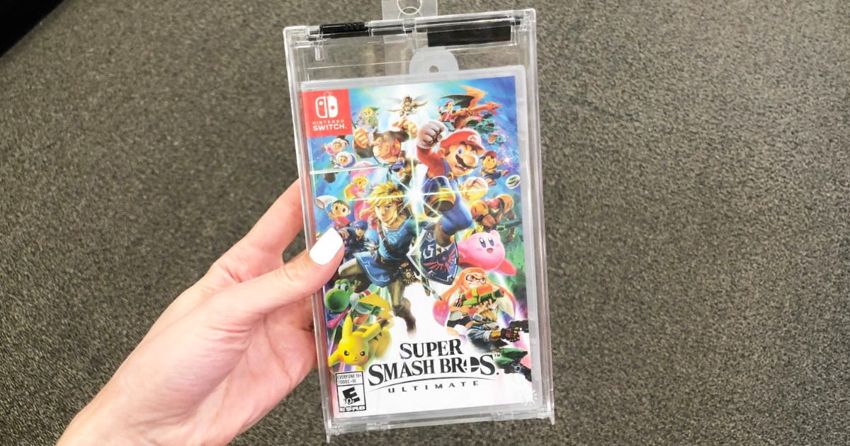 person with white finger nails holding up the case for the Super Smash Bros Ultimate Nintendo Switch game