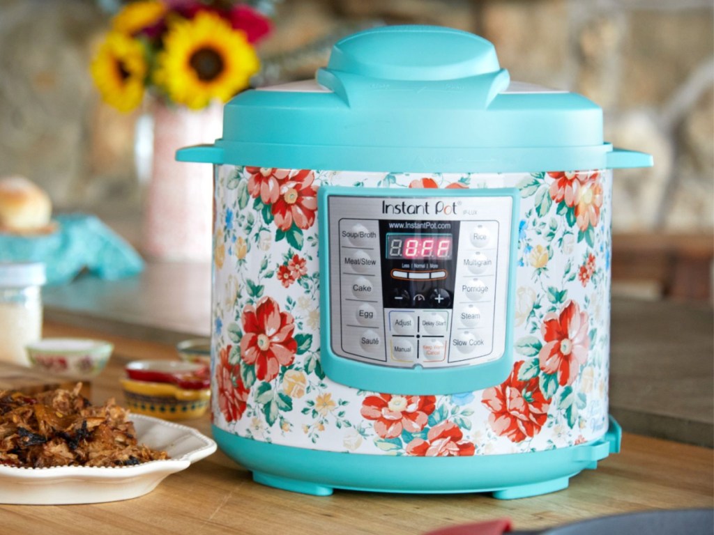 light blue floral instant pot on kitchen counter with plate of cooked meat