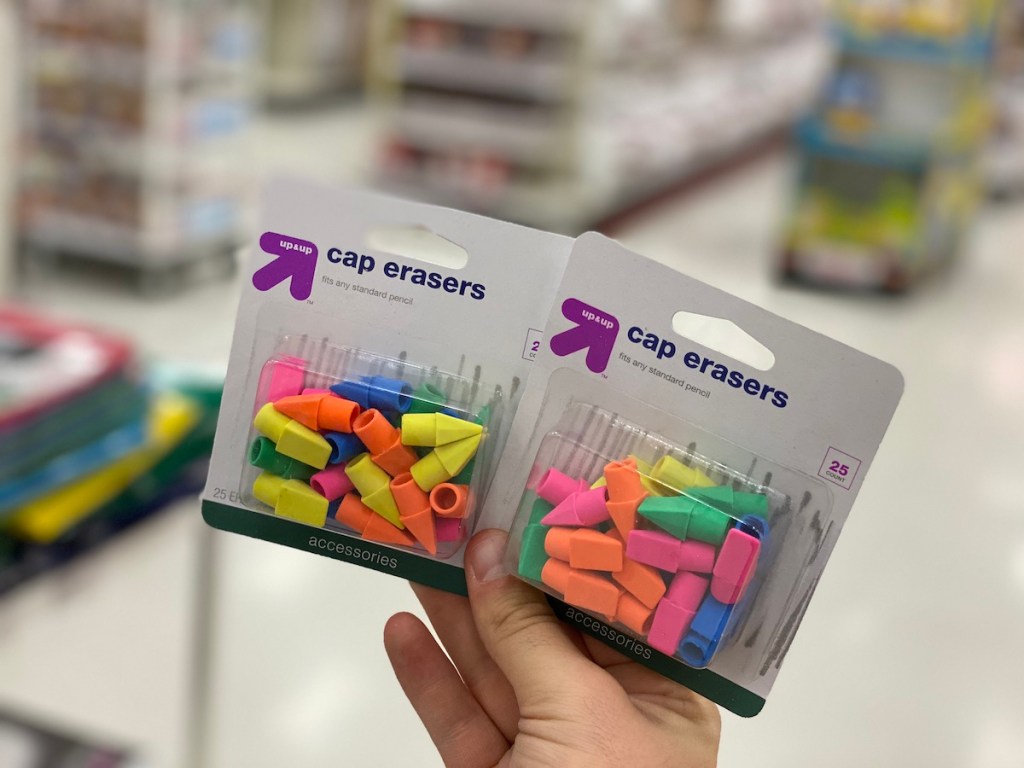 hand holding two packs of Up & Up Cap Erasers 25 Count