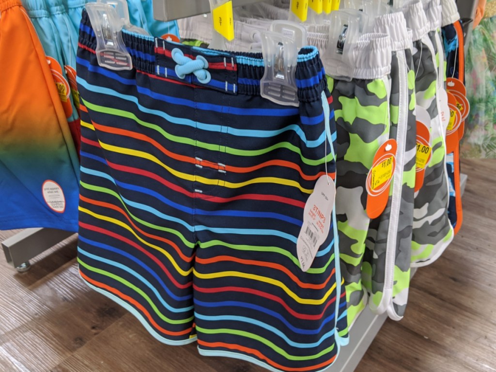 toddler boys stripe swim trunks hanging on a rack in-store