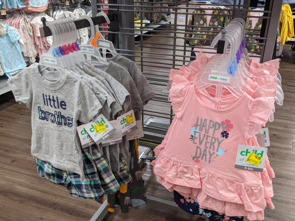 Carter's Child of Mine infant boy and girl outfits hanging in store