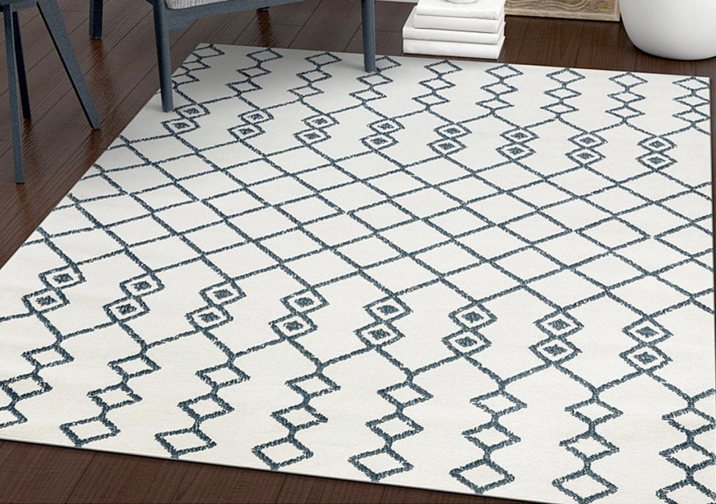 white and grey geometric print area rug on dark brown hardwood floor
