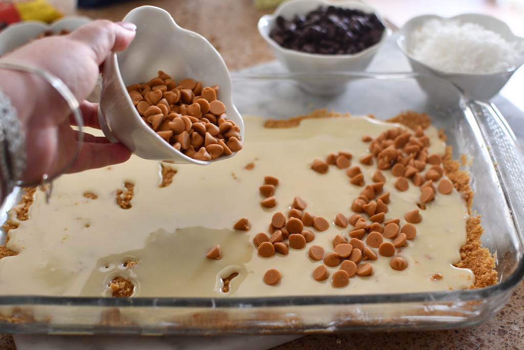 putting caramel baking chips on bars with sweeten condensed milk