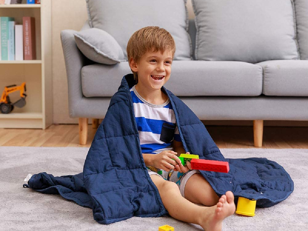 kid wrapped in navy weighted blanket