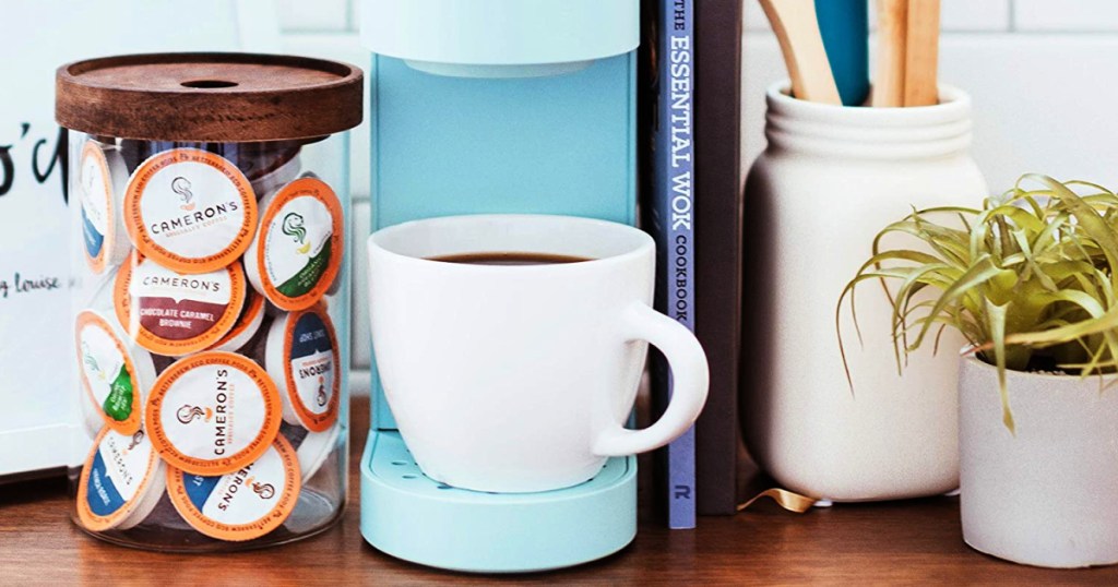 coffee cup in keurig with jar of cameron's coffee pods