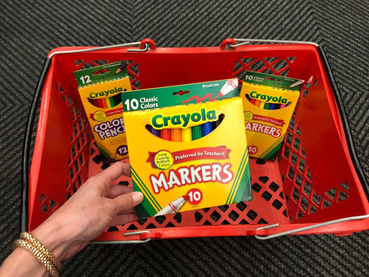 holding box of crayola markers near red basket