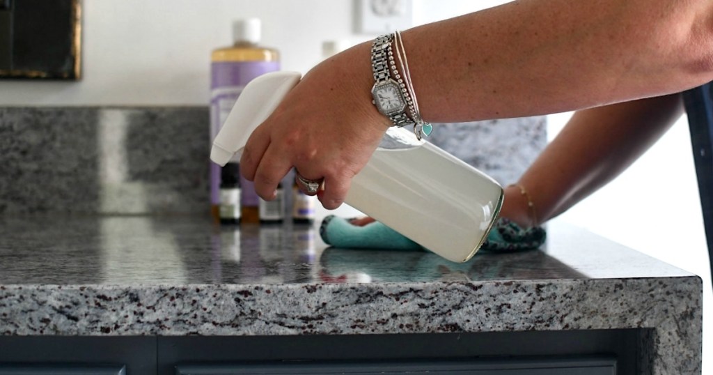 spraying DIY granite cleaner on bathroom countertop 
