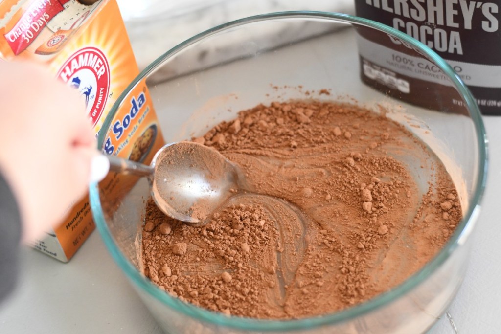 cocoa powder and glue being stirred together in a bowl