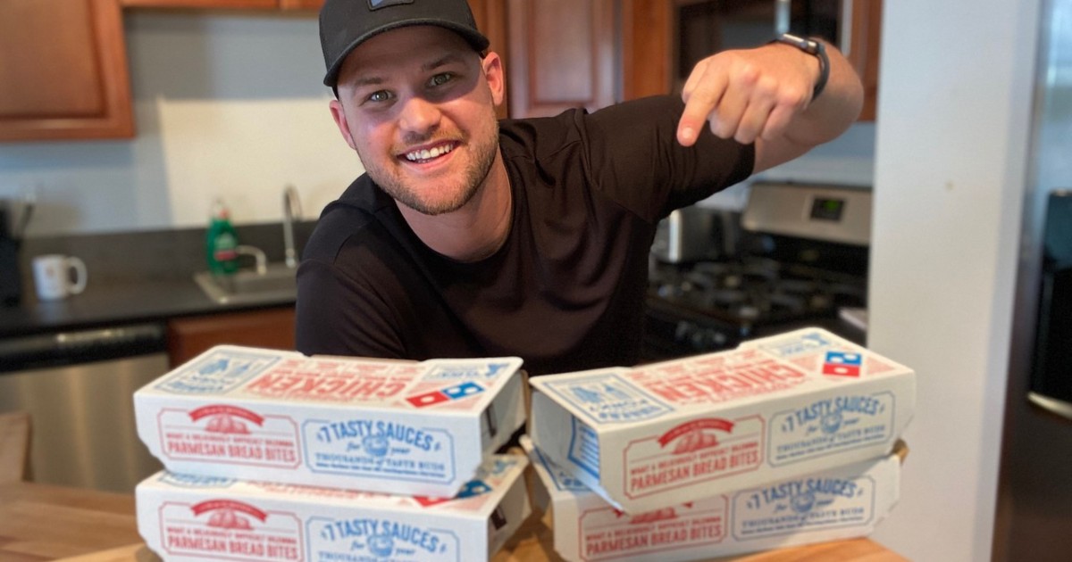 man pointing at boxes of wings from Dominos
